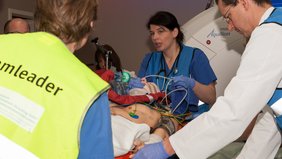 Teilnehmer des Schockraumteams mit der Simulationspuppe im Computertomographieraum (© Ursula Eisenmann) Teilnehmer des Schockraumteams mit der Simulationspuppe im Computertomographieraum