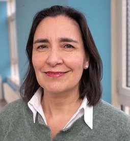 Dr. Cecilia Jara (© Johannes Lehner) Mit grauer Wollweste und heller Bluse drunter, Lippenstift, dunkelbraune schulterlange Haare