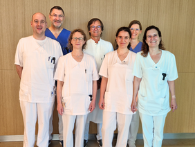 Weltdiabetestag (© Christiane Baumann) Die Gruppe vor einem Holzpaneel alle in weiß, Prof. Weigert und Frau Bischof in blau