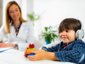 Foto eines Hörtests mit Ärztin und Kind