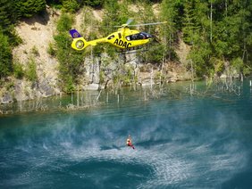 Rettungshubschrauber „Christoph 15" (© Dr. Christoph Kerscher) Foto vom Rettungshubschrauber „Christoph 15" über Wasser mit abgeseiltem Notarzt