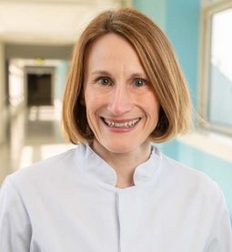 Priv. Doz. Dr. Lisa Geis (© Johannes Lehner) Dame mit dunkelblondem Bob, lachend in einem Krankenhausflur