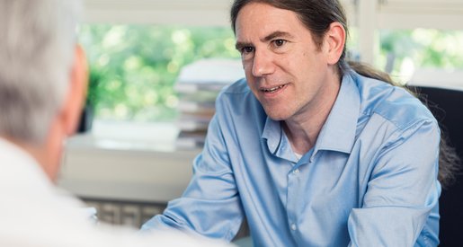 Foto vom Der Leiter des Sozialdiensts Florian Ramsauer im Gespräch mit einem Patienten